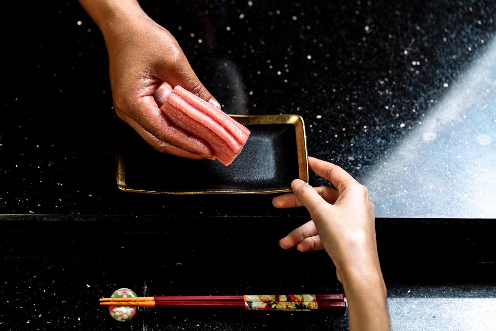 Vie Hotel Bangkok, Mgallery Kültér fotó A sushi chef holding a rectangular plate